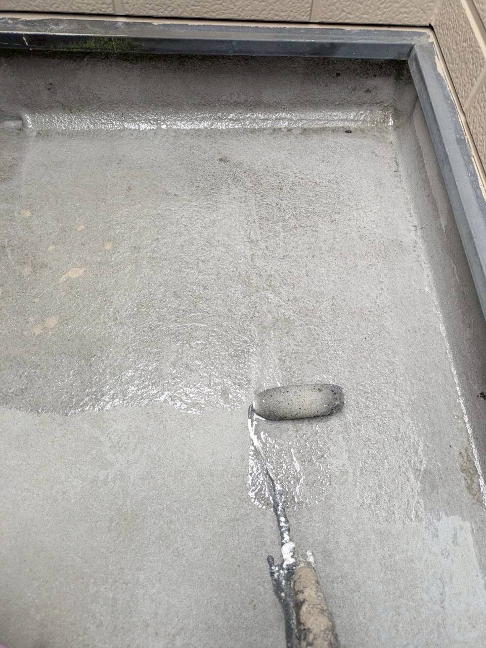 プライマー塗装を施工中のバルコニー床